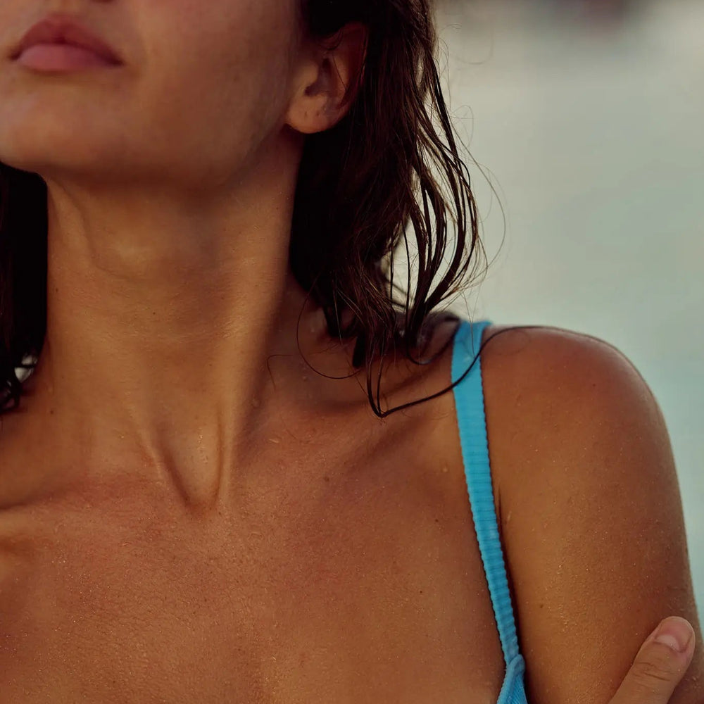 Close-up of a person wearing a blue bikini with a blurred background