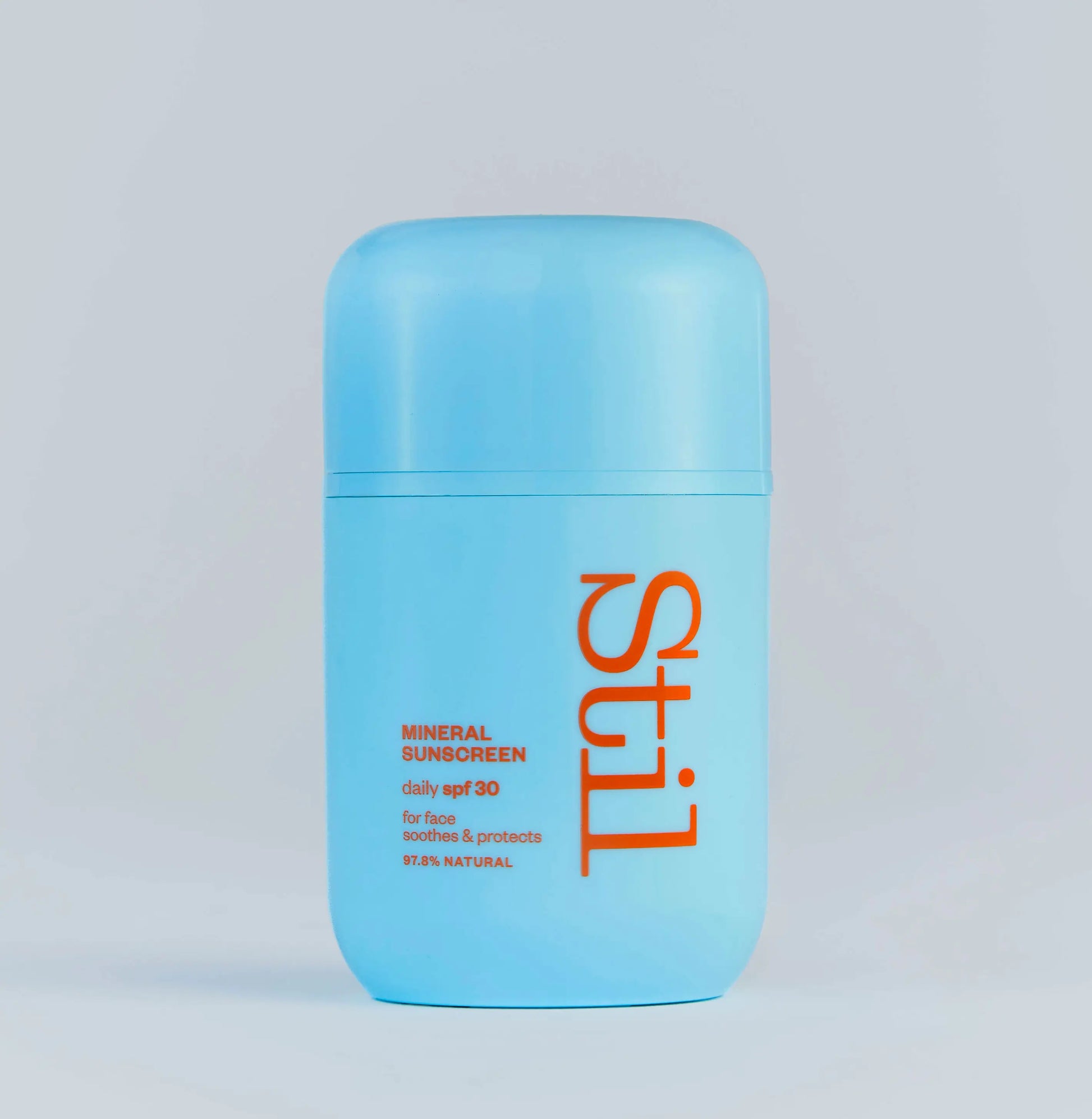 Blue sunscreen bottle with 'stil' branding on a light gray background